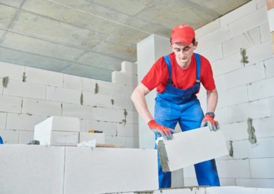 bricklayer builder working with autoclaved aerated concrete blocks. Walling